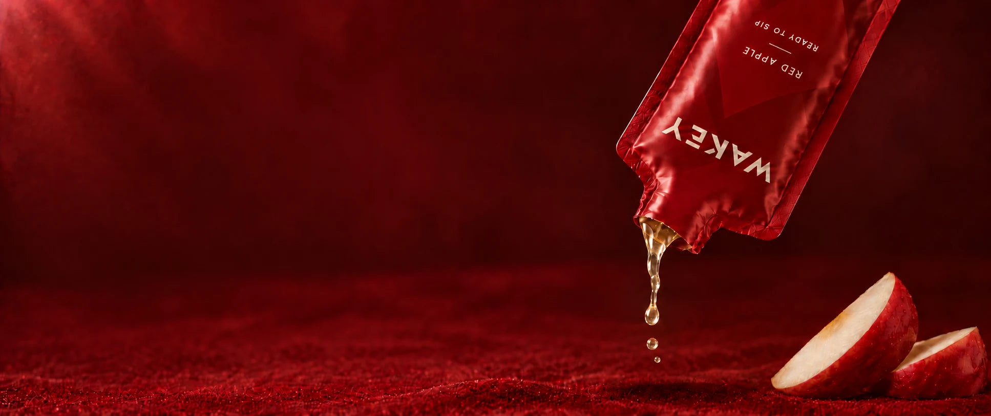 Wakey Red Apple sachet with a drop of gel beside apple slices