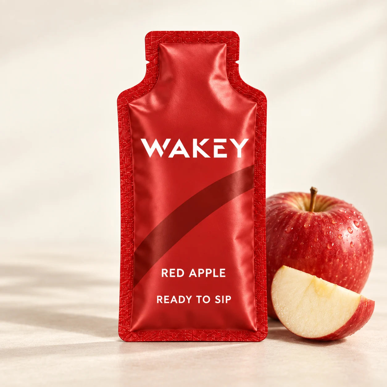 Wakey Red Apple sachet with a fresh apple on an ivory surface